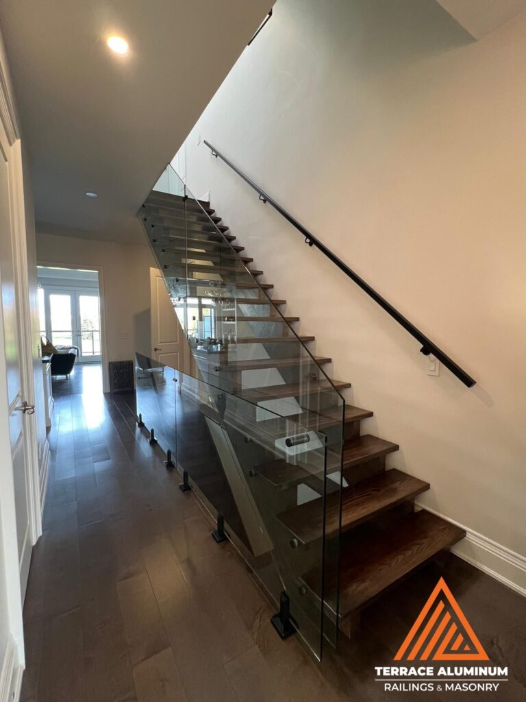 Frameless interior glass railing with stainless steel standoffs and spigots in Oakville — installed by Terrace Aluminum Railings & Masonry
