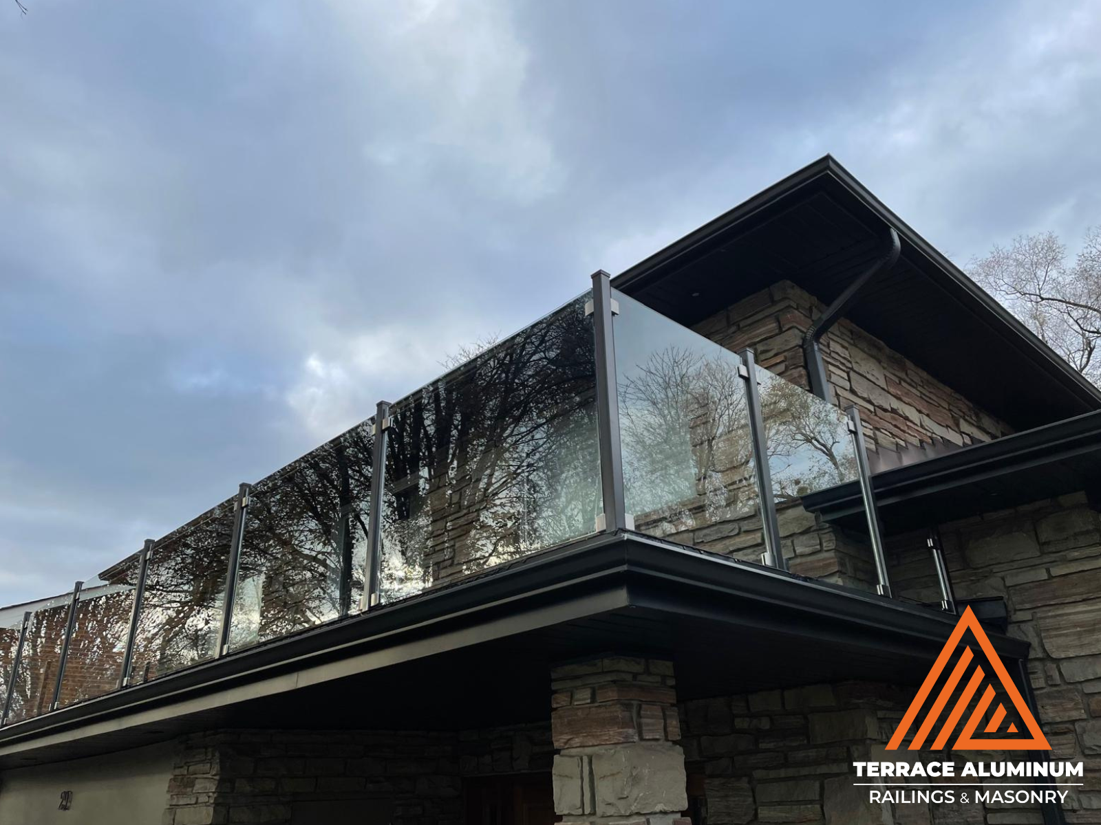 Semi-frameless glass railing on balcony in Oakville by Terrace Aluminum Railings & Masonry