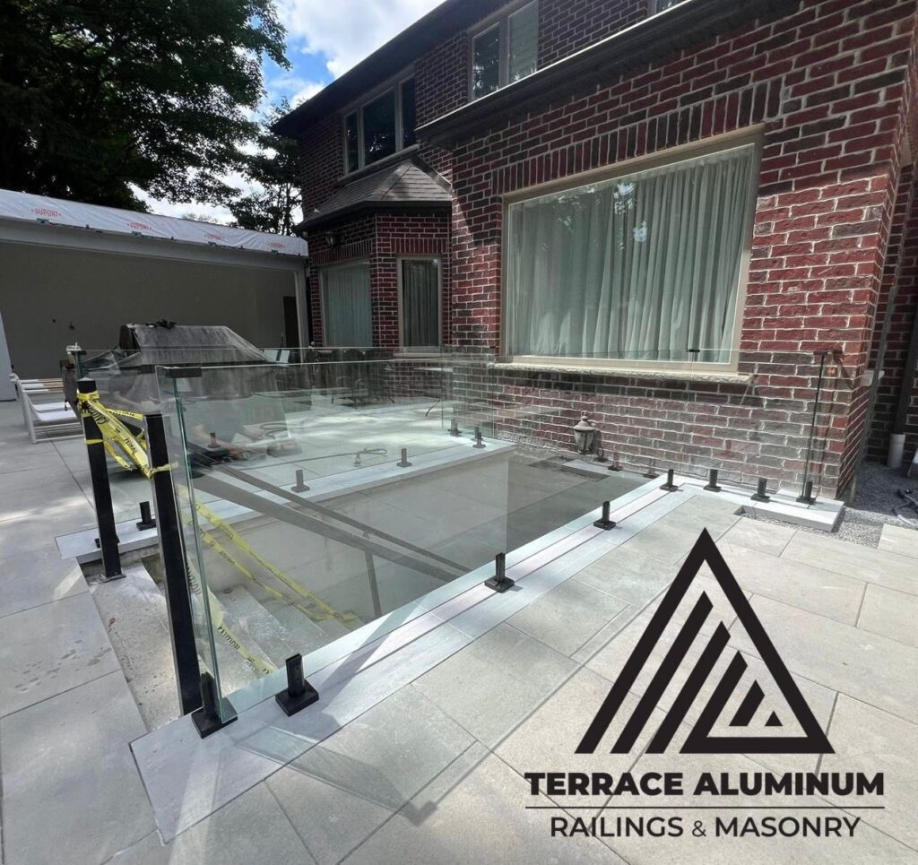 Frameless glass railing with spigots in backyard Oakville by Terrace Aluminum Railings & Masonry