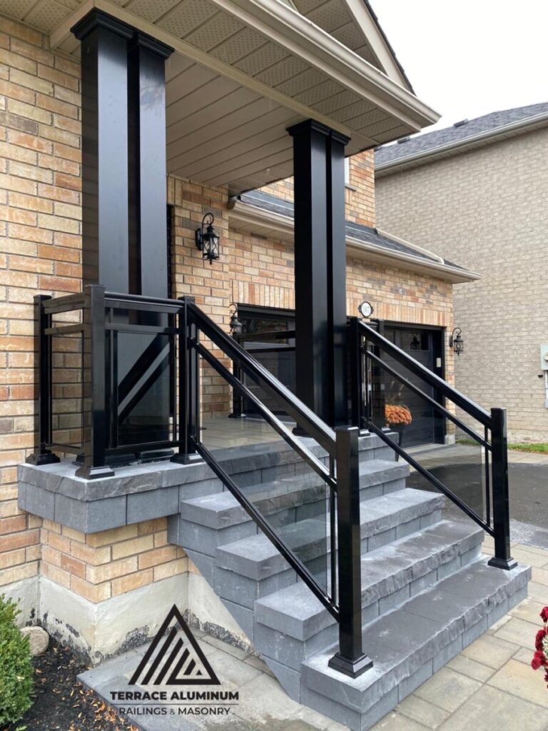 Tinted aluminum and glass railing on a front porch in Hamilton installed by Terrace Aluminum Railings, featuring bronze-tinted tempered glass panels and black aluminum posts for a stylish modern look."
