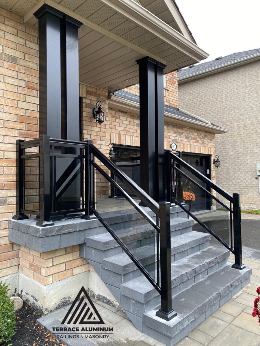Tinted aluminum and glass railing on a front porch in Hamilton installed by Terrace Aluminum Railings, featuring bronze-tinted tempered glass panels and black aluminum posts for a stylish modern look."