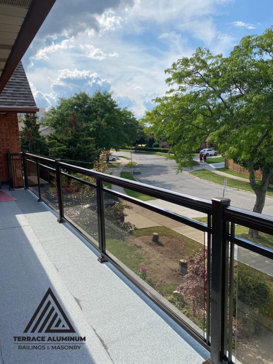 Aluminum glass railing on a balcony in Hamilton installed by Terrace Aluminum Railings, featuring clear tempered glass panels and black aluminum posts for a sleek modern look