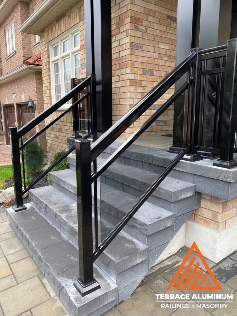 Aluminum glass railing on a front porch in Hamilton by Terrace Aluminum Railings, featuring clear tempered glass panels and durable aluminum posts for a modern exterior design.