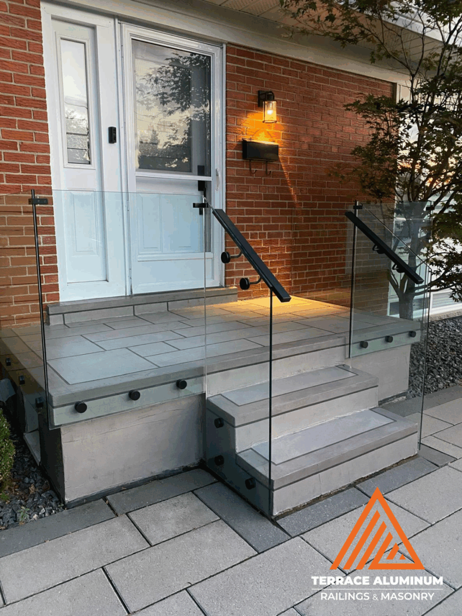 Frameless glass railing on a front porch in Hamilton installed by Terrace Aluminum Railings, featuring 12mm tempered glass panels and stainless steel hardware for a sleek modern look.