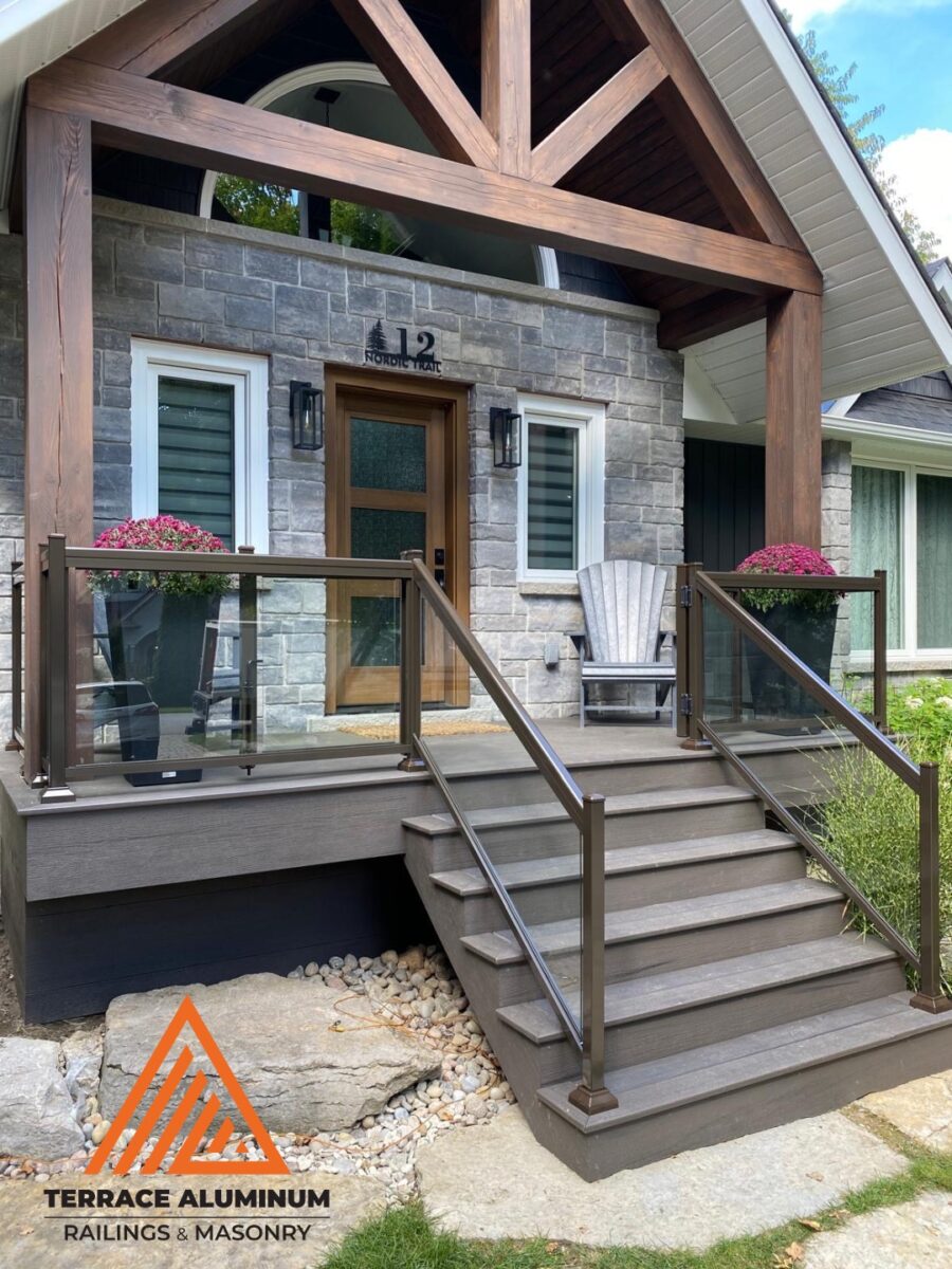 Aluminum glass railing on a front porch in Hamilton installed by Terrace Aluminum Railings, featuring clear tempered glass panels and black aluminum posts for a clean modern look.