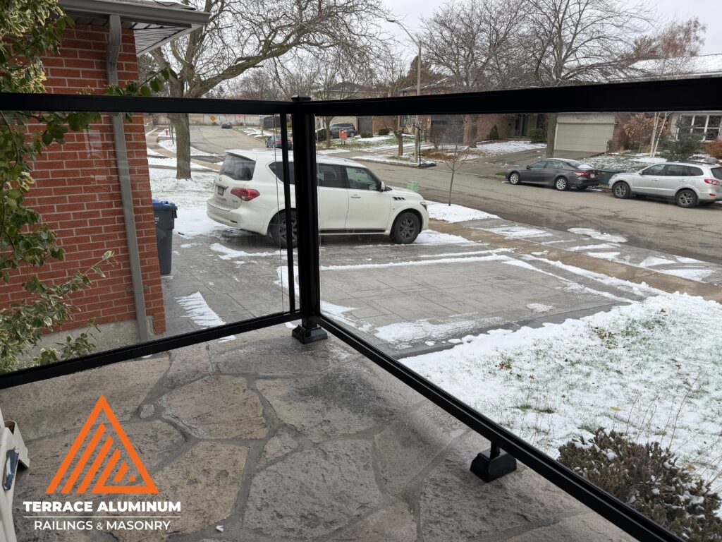 After photo of modern glass railing on rebuilt stairs and porch in Mississauga