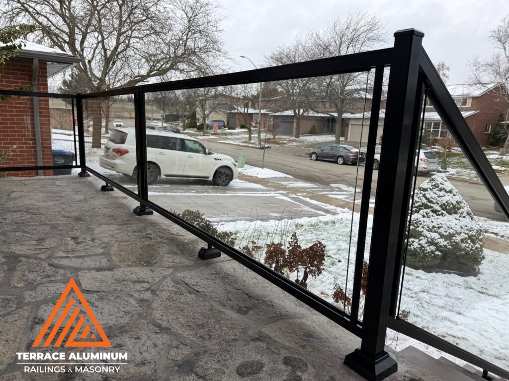 After photo of modern glass railing on rebuilt stairs and porch in Mississauga