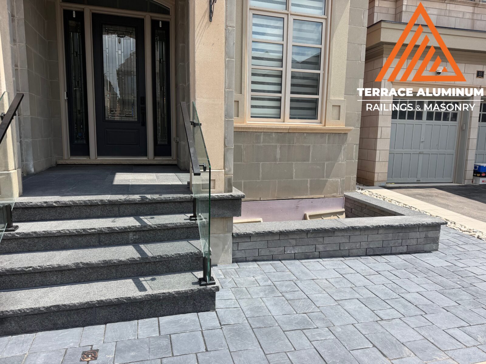Flagstone front porch with interlocking pavers and garden bed as part of a Hardscaping Oakville project