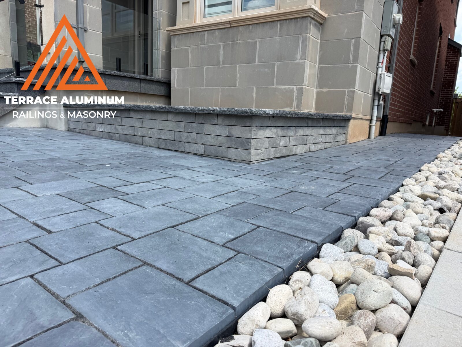 Interlock walkway with an interlock garden box and Black Pearl flagstone coping for hardscaping services in Etobicoke.
