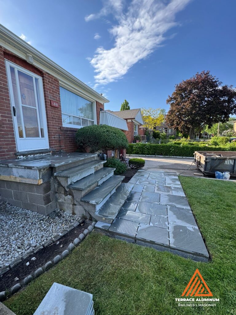 Natural flagstone walkway leading to a flagstone front porch as part of a Hardscaping Oakville project